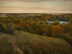 Fall colors of red, brown, and yellow through an Iowa landscape.